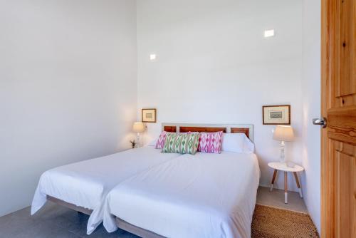 a bedroom with a large white bed with two lamps at Finca Laurel in Islas Baleares