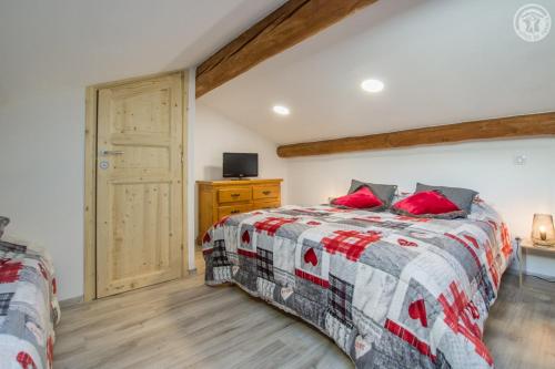 a bedroom with a bed with red pillows at Gîte Les Mélèzes in Termignon