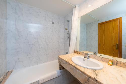 a bathroom with a sink and a bath tub at Oro del Mar iv apartamento 05 in Canyamel