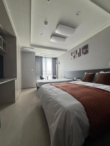 a hotel room with two beds and a television at 썸원호텔 in Yŏsu