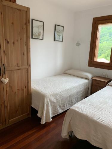 a bedroom with two beds and a window at El Mirador de Llanars in Llanars