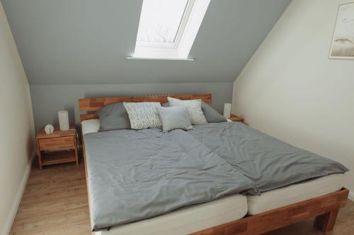 a bedroom with a large bed with gray sheets and pillows at Gästehaus Bröcker Wohnung 8 in Büsum