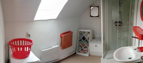 a bathroom with a red basket next to a shower at Aux souvenirs d'Antan in Broyes