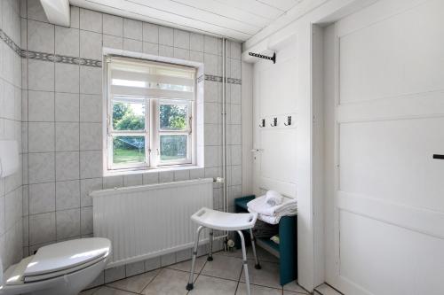 a bathroom with a toilet and a window at Friesisches Reetdachferienhaus in Bordelum