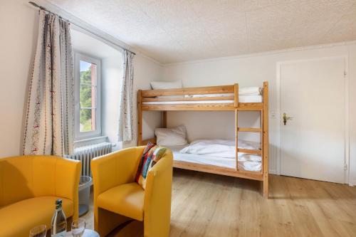 a small room with a bunk bed and a chair at Gasthaus Hirschen Holl in Elbenschwand
