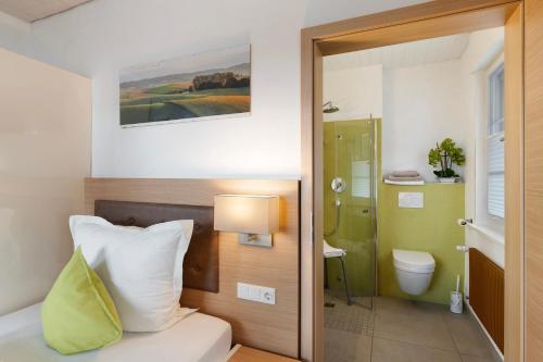 a hotel room with a bed and a bathroom at Pension Waldliesel in Dornstetten