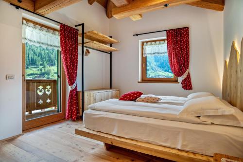 a bedroom with a large bed with red curtains at La Chiasa in Rabbi