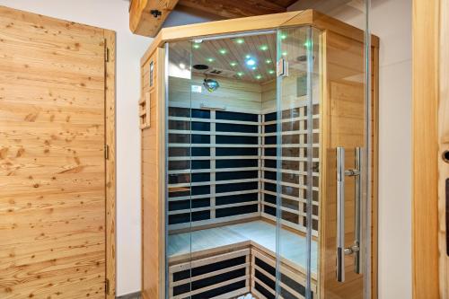 a glass shower in a bathroom with wooden walls at La Chiasa in Rabbi