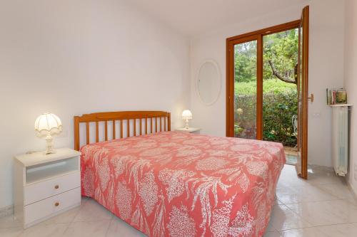 a bedroom with a bed with a red and white bedspread at Villetta a Castiglioncello in Castiglioncello