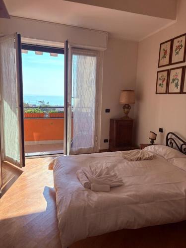 a bedroom with a large bed and a large window at Il Balcone di Anna - Nervi - 65mq Bilocale in Genoa