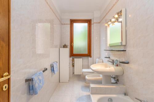 a white bathroom with a sink and a toilet at Villetta a Castiglioncello in Castiglioncello
