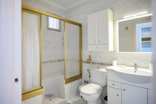 a white bathroom with a toilet and a sink at Casa López in Baena