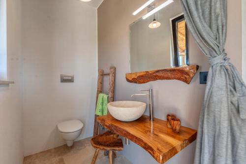 a bathroom with a wooden counter with a sink and a toilet at La casa di Rollo in Otranto