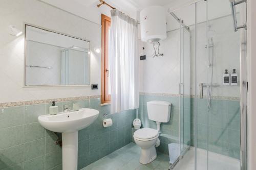 a bathroom with a sink and a toilet and a shower at Kairos San Vito Lo Capo in San Vito lo Capo