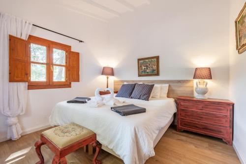 a bedroom with a large white bed and a wooden floor at ses llebres in Bunyola