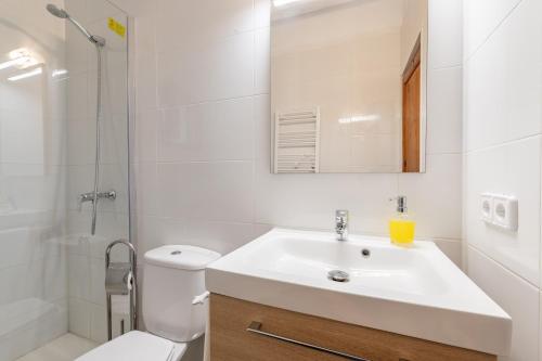 a white bathroom with a sink and a toilet at ses llebres in Bunyola
