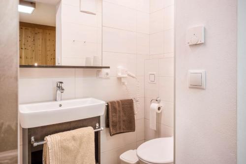 a white bathroom with a sink and a toilet at Heiserhof App Kirsche in Racines