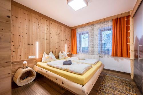 a bedroom with a bed with a wooden wall at Heiserhof App Kirsche in Racines