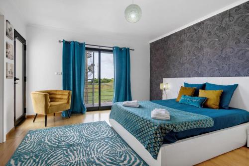 a bedroom with a blue bed and a window at Casa da Orquidea in Ribeira Grande