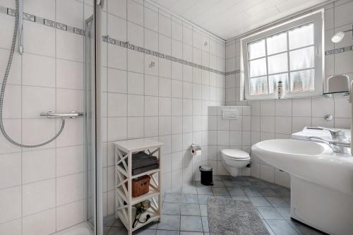 a white bathroom with a sink and a toilet at Ferienwohnung-Reil in Wardenburg