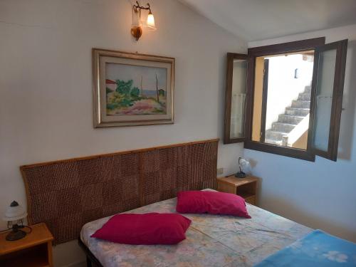 a bedroom with a bed with red pillows on it at Casina Torre in Torre Dei Corsari