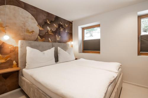 a bedroom with a large bed with white sheets at Appartements N°37 in Hüttschlag