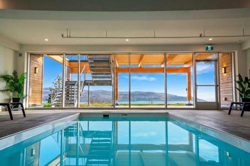 a swimming pool with a view of a house at 310 - Luxury Condo The Serenity - View and Pool in Baie-Saint-Paul