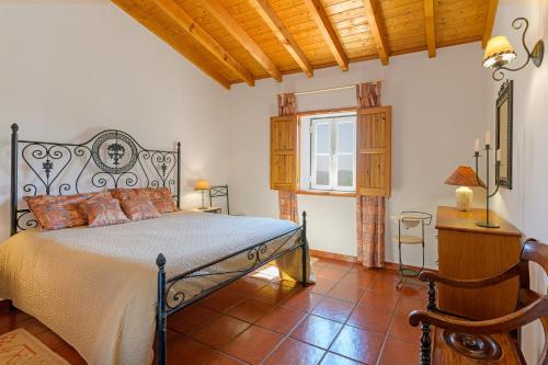 a bedroom with a bed and a table and a window at Monte do Cerro Verde in Santiago do Cacém