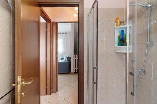 a bathroom with a walk in shower and a glass door at Il Frutteto 49 in Ortovero