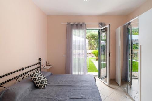a bedroom with a bed and a sliding glass door at Il Frutteto 49 in Ortovero