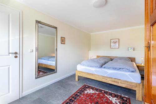 a bedroom with a bed and a mirror at Ferienhaus Erlengrund B in Schafstedt