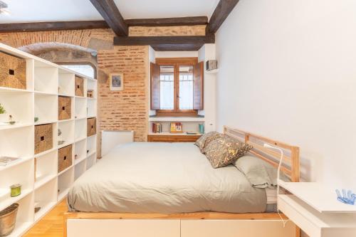 a bedroom with a bed in a room with shelves at Judería Apartamento in Segovia