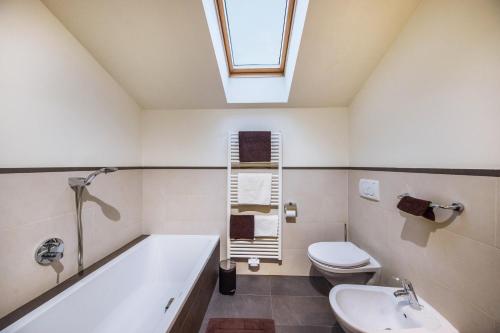 a bathroom with a tub and a toilet and a sink at Apartement Huck in Cornedo all'Isarco