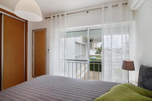 a bedroom with a bed and a large window at Costa Cabanas 1 in Cabanas de Tavira