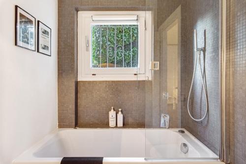 a bath tub in a bathroom with a window at Charming Lake View Bellagio in Bellagio