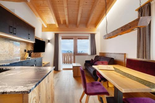 a kitchen and living room with a table and a couch at Oberplatzer in Lagundo