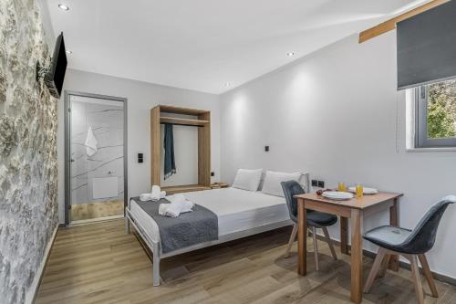 a bedroom with a bed and a desk and a table at Groundfloor Studio 1 in Tsoukalades
