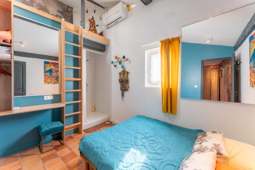 a bedroom with a blue bed in a room at En plein centre d'Avignon in Avignon