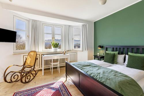 a bedroom with a bed and a desk and windows at Attendorner Burgblick in Attendorn