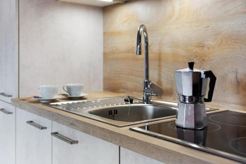 a kitchen with a sink with two cups on a counter at Schnellehof in Velturno