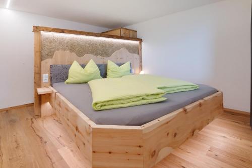 a bed with a wooden frame in a room at Gurschlerhof in Lasa