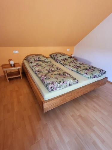 a bedroom with two beds and a wooden floor at Ferienwohnung Huber in Oppenau
