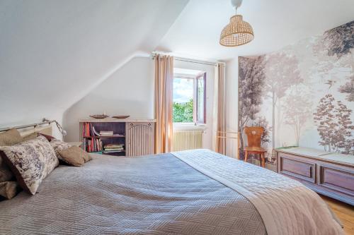 a bedroom with a large bed and a window at La Colline aux Oiseaux in Tieffenbach