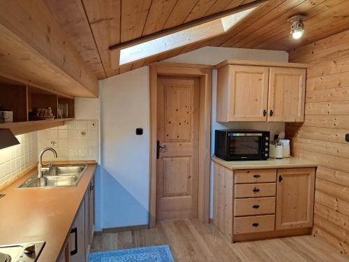 a kitchen with a sink and a microwave at Haus Sunnleitn Vogelsang in Bayrischzell