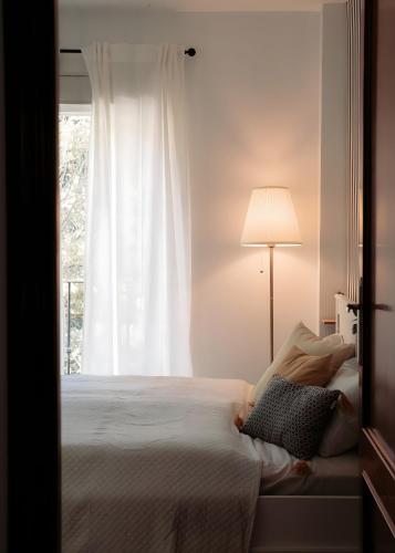 a bedroom with a bed with a lamp and a window at Casa de Manuel in Pinos Genil