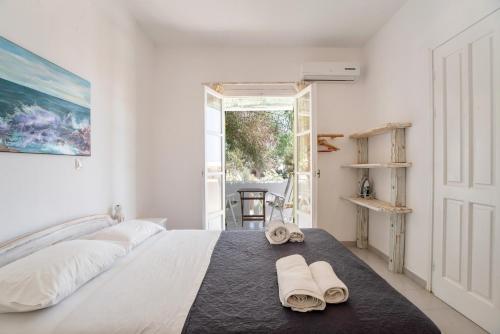 a white bedroom with a bed with towels on it at Green Retreats 5 Paros in Isterni