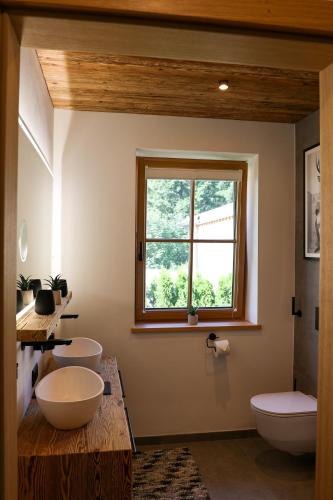 a bathroom with two sinks and a window at Chalet Almblick mit Sauna in Tauplitz