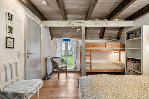 a bedroom with a bunk bed and a chair at Ferienwohnungen Am Westerdeich in Rodenäs