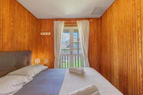 a bedroom with a large bed and a window at Appartamenti Petite Cerise in Pila
