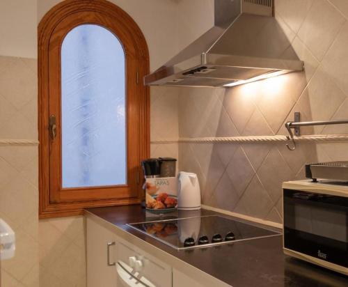 a kitchen with a counter with a stove and a window at Apartamento el Rojo 2 in Can Picafort